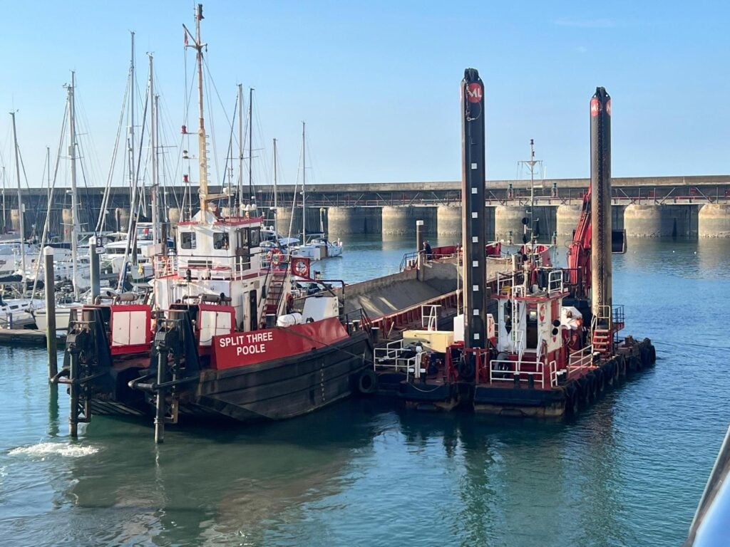 Red dredging boat in a marina